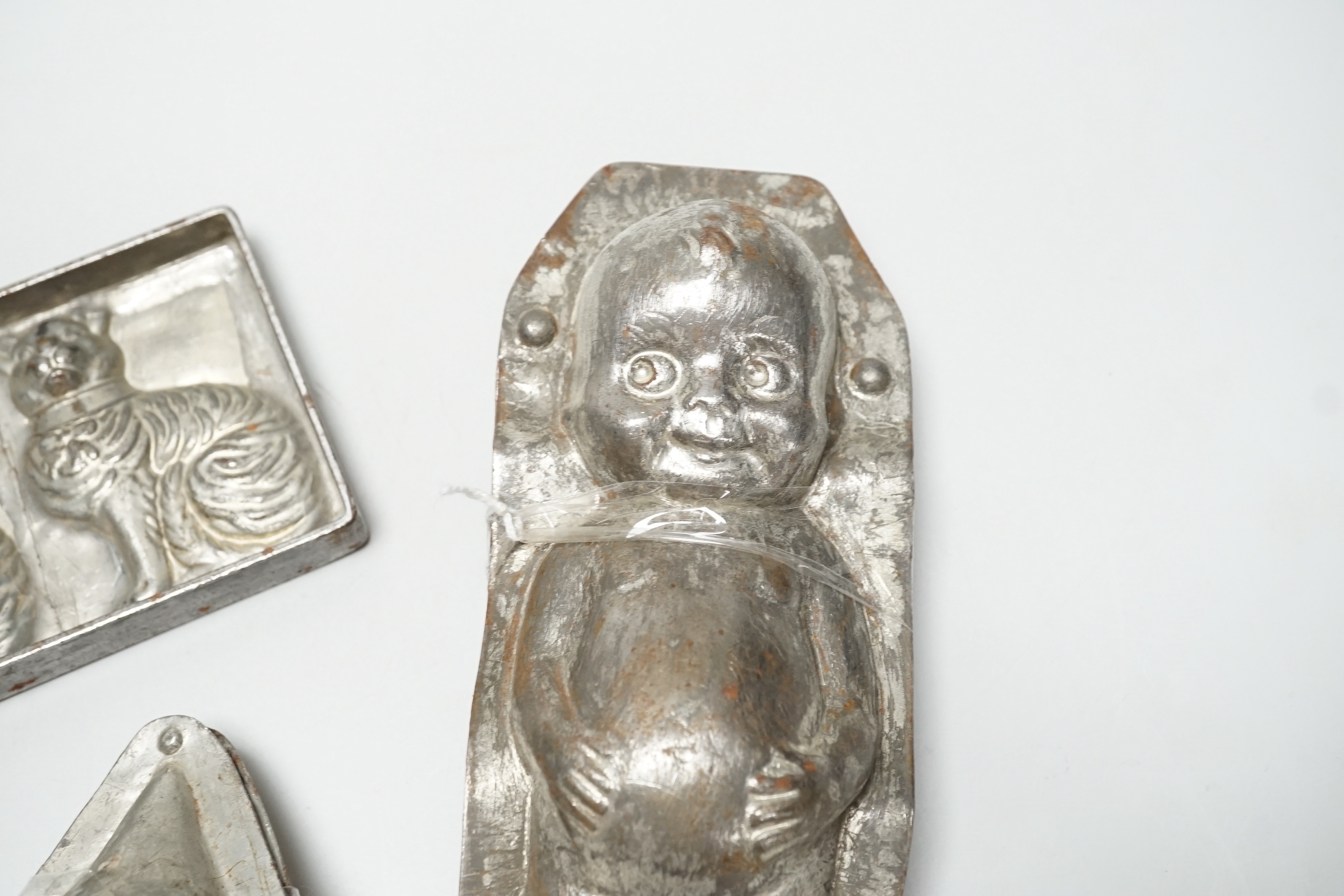 Four chocolate mould tins: a cat, a kewpie and two others